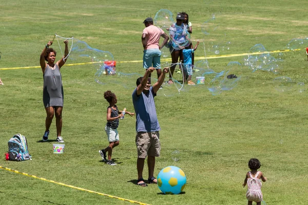 Los padres hacen grandes burbujas con agua jabonosa en el Festival de Atlanta —  Fotos de Stock