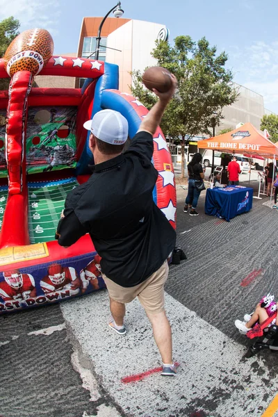 Hombre lanza fútbol hacia objetivos en la universidad Fan Fest —  Fotos de Stock