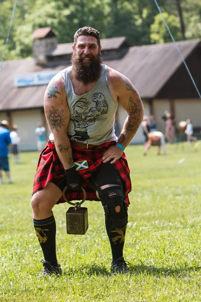 Hombre se prepara para cabestrillo peso sobre la barra en Highland Juegos —  Fotos de Stock