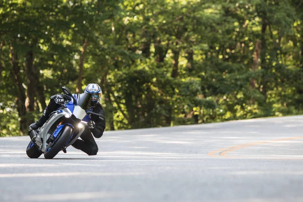 Motorkerékpár racer Leans a turn on hétvégi Ride through Mountains — Stock Fotó