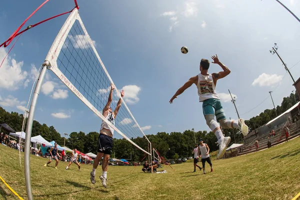 Fisheye vista di uomo Spiking palla in erba torneo di pallavolo — Foto Stock