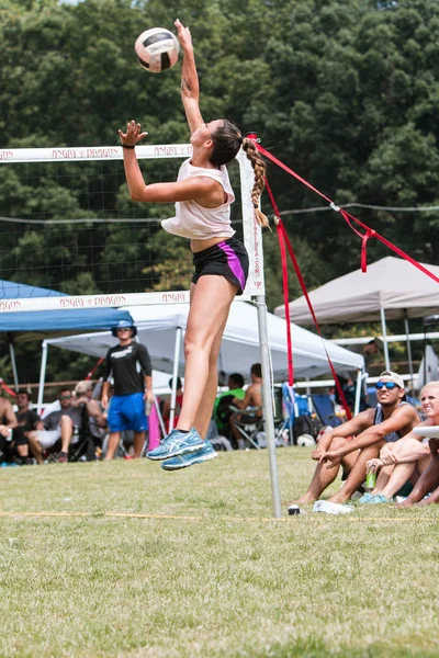 Donna salta alla palla a spillo in tripli torneo di pallavolo erba — Foto Stock