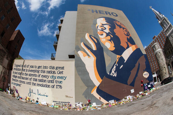 Atlanta, GA, USA - August 1, 2020:  Flowers, tributes and messages sit at the base of the iconic John Lewis mural on Auburn Avenue two days after his funeral, on August 1, 2020 in Atlanta, GA. 