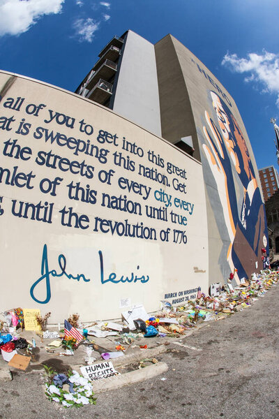 Atlanta, GA, USA - August 1, 2020:  Flowers, tributes and messages sit at the base of the iconic John Lewis mural on Auburn Avenue two days after his funeral, on August 1, 2020 in Atlanta, GA.