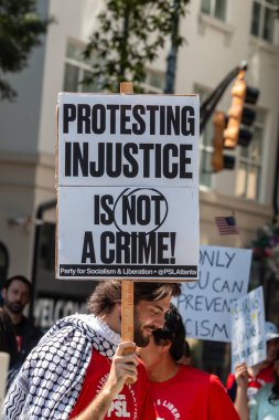 Atlanta, GA / ABD - 1 Eylül 2025: İnsan 1 Eylül 2025 'te Atlanta, GA' da İşçi Bayramı mitinginde protesto işareti taşıyor..