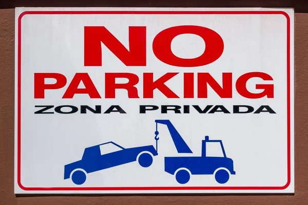 Spanish No Parking Sign with car being towed illustration