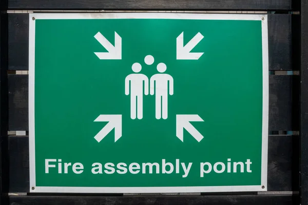 Fire Fire Assembly Point sign on a black fence — ストック写真