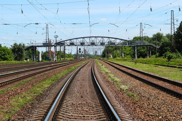 Trensiz raylar. Demiryolu üzerinde arka planda yaya köprüsünde.