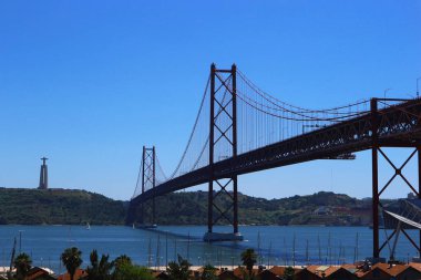 Cristo Rei Sanctuary ile Tagus veya Tejo nehri üzerinde Asma Köprüsü. Lizbon ve Almada şehirlerini birbirine bağlar. 25 de Abril Bridge, Lizbon, Portekiz.