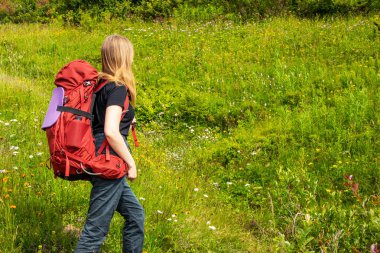 Dağ yolu içinde sırt çantası trekking ile genç kız.