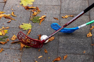 Lviv, Ukrayna - Ekim 2019. Dışarıda sonbaharda florbol oynuyorum. Düşmüş sarı yapraklar, beyaz gülleli toplar yakın mesafede..