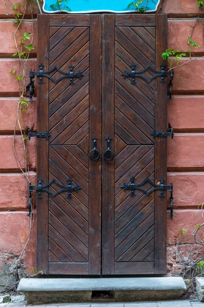 Vintage Brązowe Drewniane Drzwi Kute Zawiasy Starym Mieście Zamknięte Drzwi — Zdjęcie stockowe