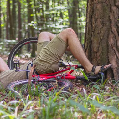 Parkta bisiklet sürerken bir adam ağaca çarptı. Bisiklet sürerken bir kaza. Sigorta konsepti.