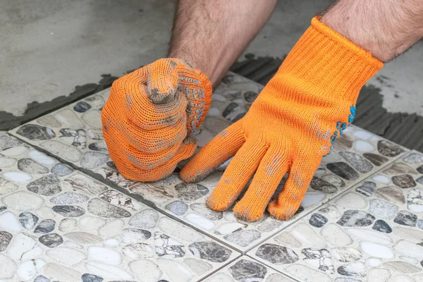 一个铺瓷砖的工人用拳头敲敲瓷砖以平整瓷砖 把瓷砖铺在地板上的过程 靠近点 — 图库照片