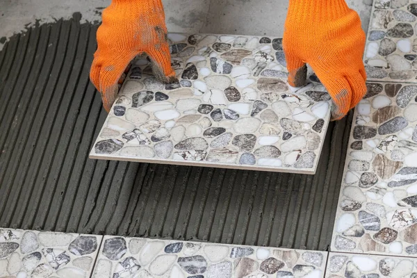 男性的手握住瓷砖 用胶水涂在地板上 铺瓷砖的过程 靠近点 — 图库照片