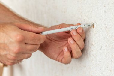 İşçi plastik fişi bir deliğe sokuyor. Kapat..