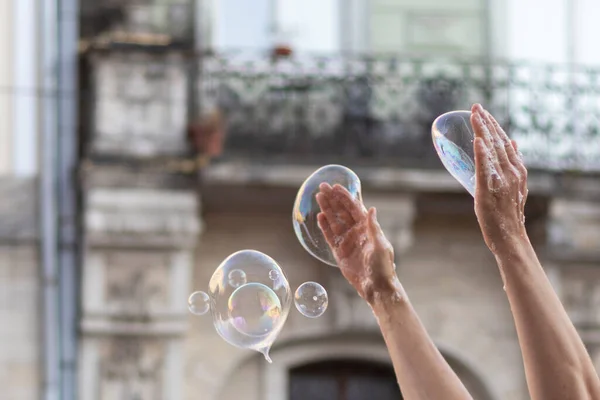 Street artist making soap bubbles. Hands and soap bubbles close up.