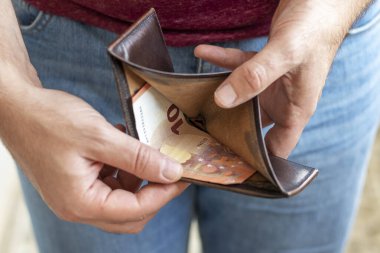 Zavallı adam 10 avroluk bir banknotla cüzdanı açtı. Ekonomik kriz ve yoksulluk kavramı.