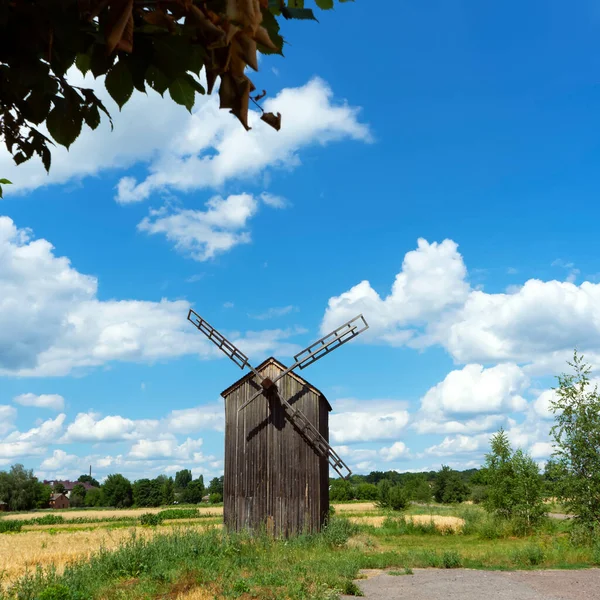 DYKANKA, UKRAINE - 10 Temmuz 2020: Kochubey ailesi tarafından 19 yüzyılda Ukrayna 'nın Dykanka kentinde inşa edilen Saint Nicolas Kilisesi yakınlarındaki Windmill. 
