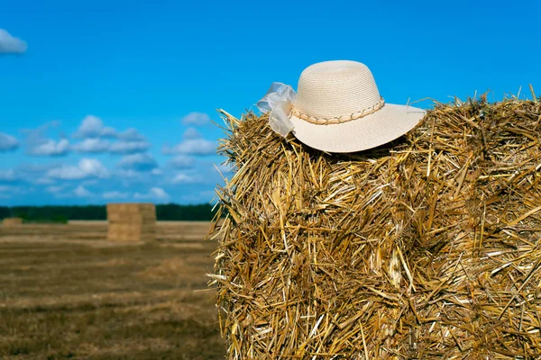 麦藁女帽子オン干し草ベール上の青い空の背景 — ストック写真