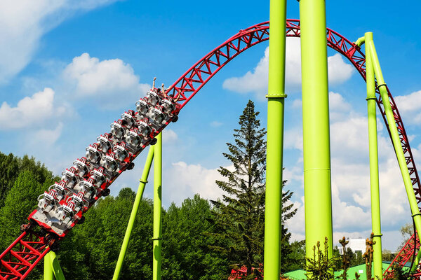 Американские горки и качели люди веселятся Хорошая погода
