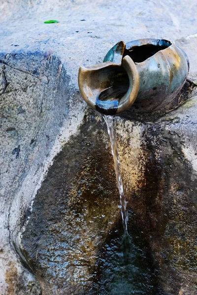 clay jug,water is drop from clay jug in the garden.