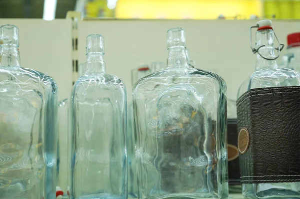 在工厂里空出玻璃瓶要装满饮料 背光是背景 — 图库照片