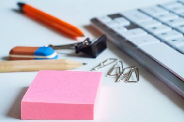 Masanın üzerine iş öğeleri, bir hesap makinesi, bir kalem ve bir kalem bir elastik bant ile vardır. Masaüstü bilgisayar için klavye. Ataç düğmeleri ve diğer ofis, iş için.