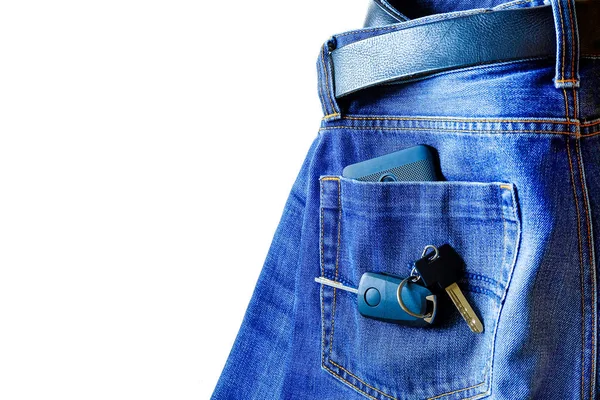 Jeans on white background. smartphone in your pocket. on top of the keys to the car
