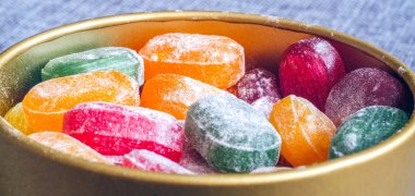 Bir kavanoz parlak şeker. Bir sevinç çocuk, çok tatlılar. Çeşitli renkler şeker. Karamel toz şeker. Renkli şeker. Kırmızı sarı yeşil turuncu.