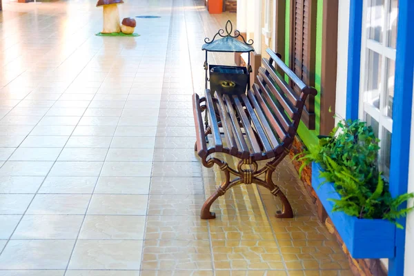 Wooden Bench for Rest under the Window. Flowers by the window and bench.