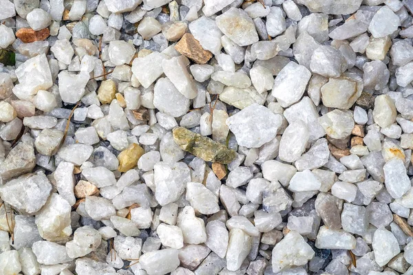 This is a crushed white stone background. White crushed stone. Gravel coating tracks. The texture of the gravel.