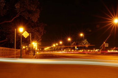 Gece şehir sokak ışıkları, bokeh, arka plan, karanlık. Şehrin ışıkları gece ışıkları gelen ışınları. Farların üzerinden açık döngü.