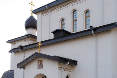 Beyaz tuğla ile karanlık çatı inşaatı. Trafik ışıkları kaldırımda. Güneş batımında. Gökyüzü günbatımı parlak renkleri ile aydınlatılmış.