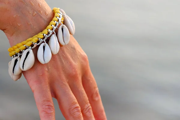 Close Mão Uma Menina Gentil Com Uma Pulseira Feita Conchas — Fotografia de Stock