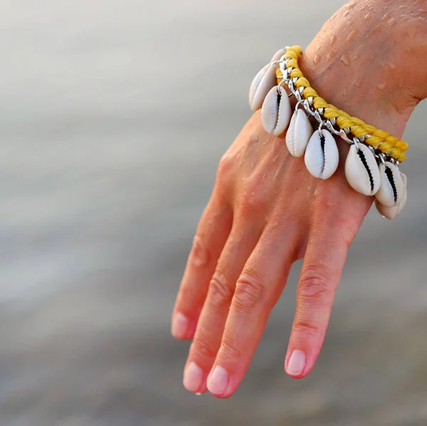 Close Mão Uma Menina Gentil Com Uma Pulseira Feita Conchas — Fotografia de Stock