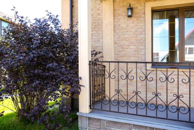 Kır evi taş adımları ile. Ve dövme metal korkuluk.