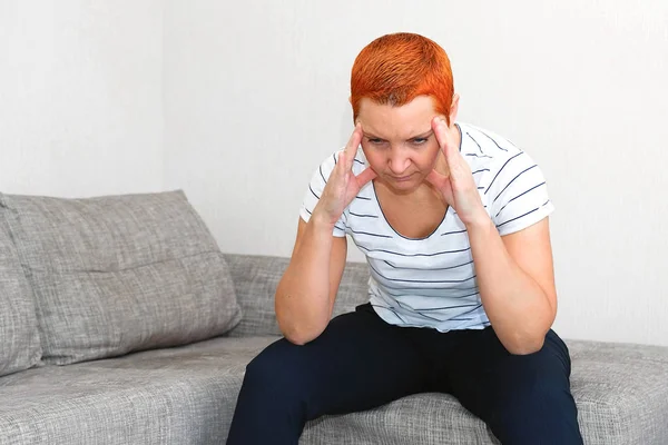 Massiert seine Schläfen. eine Frau, die unter Kopfschmerzen leidet. Gesundheitliche Probleme,. Frau hält ihren Kopf mit der Hand. — Stockfoto