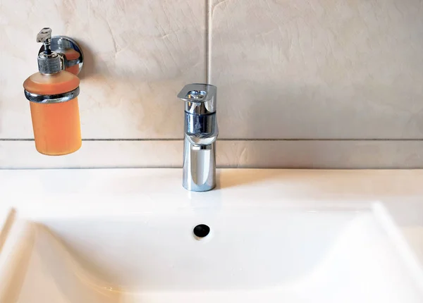 Směšovač vody v jímce. Nástěnná dekorace s keramickými obklady v koupelně s umyvadlem — Stock fotografie