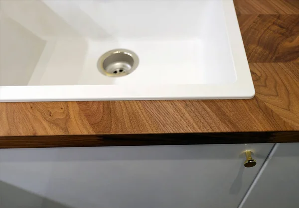 Sink for washing dishes in the kitchen. Kitchen table with cupboard.