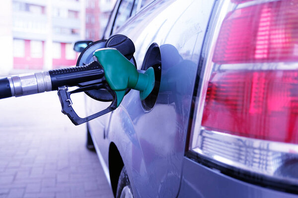 man pumping gasoline into the car at the gas station-transportation concept