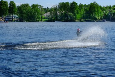 Atlet-wakeboarder havada bir atlama bir takla ile gerçekleştirir. Güneş ışığında.