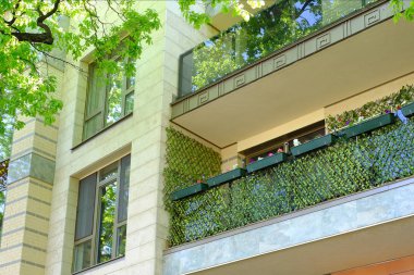 yatılı yazlık. çiçekli bitkiler balkonda. ağaçlar serin gölgesinde yürüyor. Üst düzey iki Park içinde