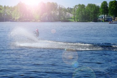 Atlet-wakeboarder havada bir atlama bir takla ile gerçekleştirir. Güneş ışığında.