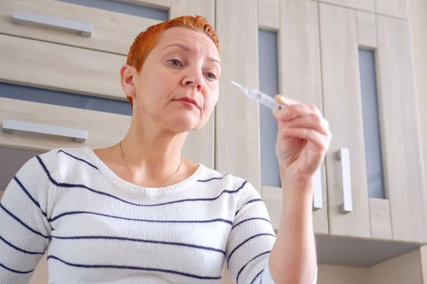 Frau mit Thermometer in der Hand. erhöhte Körpertemperatur — Stockfoto