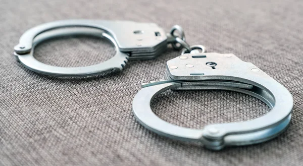 The cuffs on the table. Police unit. Close-up top view selective focus. — Stock Photo, Image