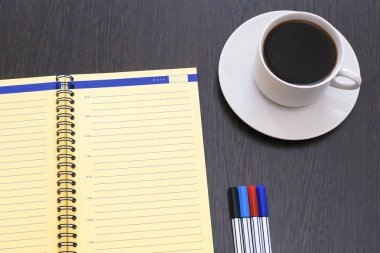 Açık günlük, planlayıcısı ve işaretleri. Espresso kahve üzerinde eski bir ahşap masa.