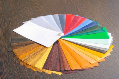 Laminasyon örnekleri. Laminasyon yapımında kullanılan ahşap ve plastik ürünleri için ahşap arka plan üzerinde.