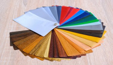 Laminasyon örnekleri. Laminasyon yapımında kullanılan ahşap ve plastik ürünleri için ahşap arka plan üzerinde.