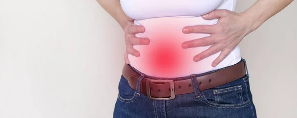 Área de dor fundo vermelho. Uma mulher que sofre de dor abdominal . — Fotografia de Stock